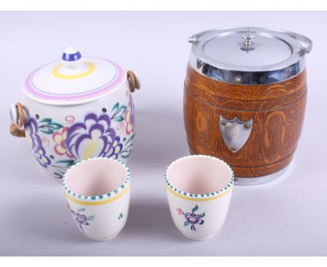A Poole pottery biscuit barrel, two similar beakers, and an oak biscuit barrel with plated mounts