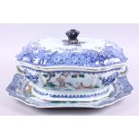 An 18th century blue, white and polychrome tureen, lid and stand, decorated flowers, figures and