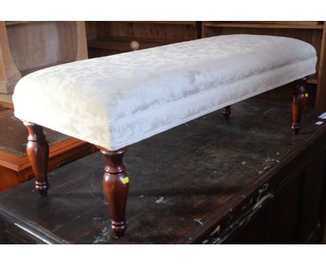 A polished as mahogany fender stool, on turned supports, 42" long