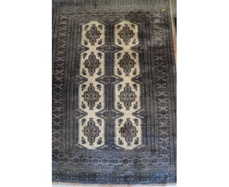 A Bokhara rug with eight medallions on a light ground and multi bordered in shades of pink, grey, black and natural, 74" x 51