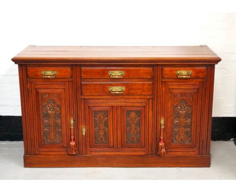 EDWARDIAN OAK SIDEBOARDwith a moulded top, above four panelled drawers and a central carved panel cupboard door flanked by a 