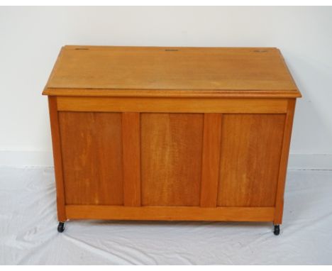 STAINED WOOD BLANKET BOXwith hinged lid, board base panel, raised on wheels, 65cm high x 95cm wide x 49cm deep
