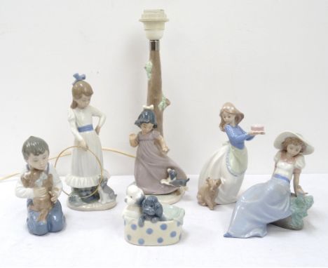 SELECTION OF NAO BY LLADRO FIGURINEScomprising a young boy kneeling with his dog on his lap, 15cm high; a lady reclining on a