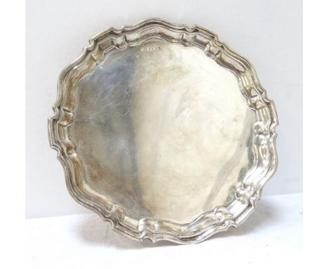 EDWARDIAN SILVER WAITERof circular form with a pie crust border, raised on three scroll supports, 300g, Sheffield 1906