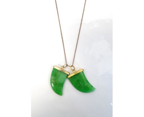 TWO JADE CLAW SHAPED PENDANTSwith gilt mounts, on a nine carat gold chain, the pendants approximately 2.6cm high