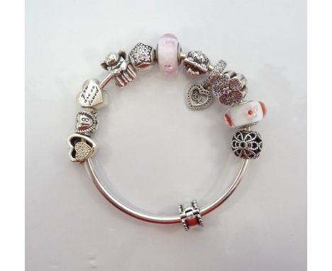 PANDORA SILVER CHARM BANGLEwith ten various charms and a clip, the charms including a flower, an angel and glass and openwork