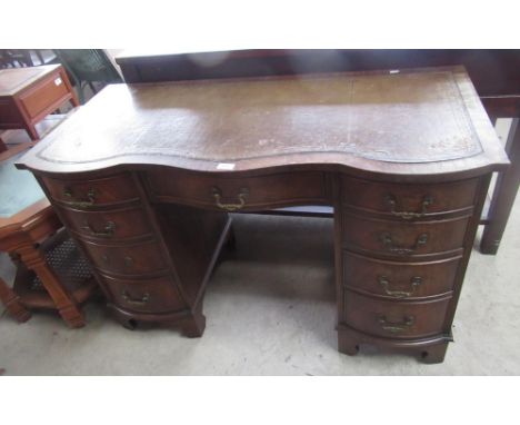 Bevel funnel reproduction Geo. III style mahogany kneehole desk with serpentine leather inset top and drawers on bracket feet