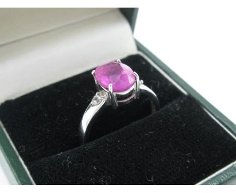 9ct white gold and pink ruby dress ring, central stone flanked by two small diamonds, size N 