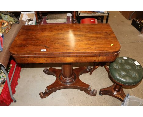 A 19th Century rosewood fold over card table with swivel top raised on a cylindrical column and quatrefoil base