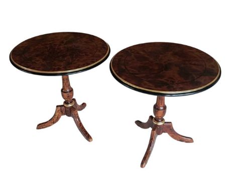 A pair of reproduction walnut/yew effect circular tripod lamp tables, with ebonised and gilt border, diameter 60cm (2).