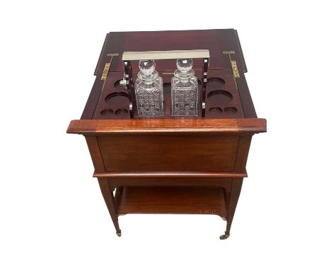MAPLE &amp; CO; an Edwardian mahogany ‘surprise’ pop-up drinks cabinet, enclosing a compartmented interior with two decanters