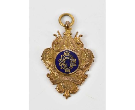 A 9ct yellow gold and enamelled cricket medallion with crossed bats, balls and stumps above the enamelled plaque and date of 