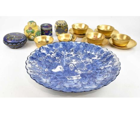 An early 20th century Japanese blue and white ceramic charger, with scalloped edge, decorated with elders and children, diame