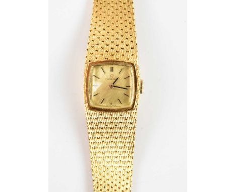 OMEGA; an 18ct yellow gold lady's wristwatch, with integral textured bracelet, the dial set with baton markers and with 17 je