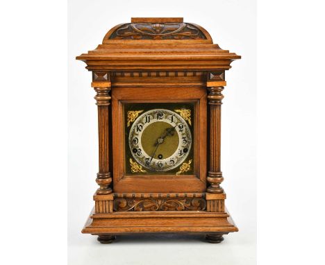 An early 20th century carved oak mantel clock, with brass dial set with Arabic numerals, movement stamped 'Made in Wurttember