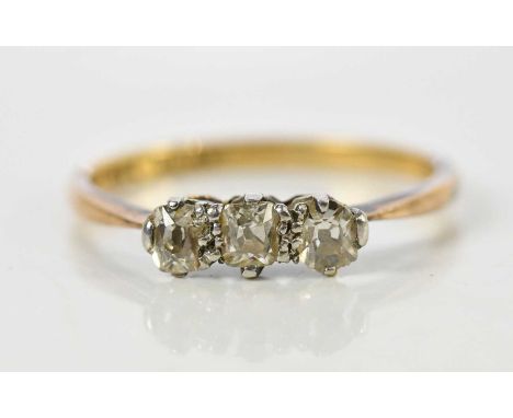 An 18ct yellow gold three stone diamond ring, set with cushion cut stones totalling approx 0.35ct, size M, approx 1.8g.