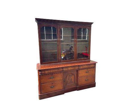 A large Victorian mahogany bookcase, with moulded cornice above three glazed doors, the base section with three cushion drawe