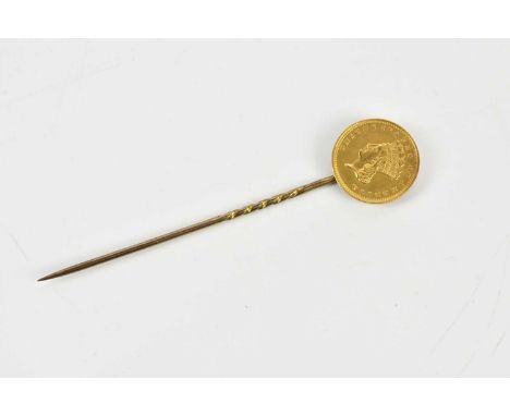 A yellow metal stick pin set with American one dollar gold coin, approximate weight 2.6g.   Condition Report: Year on coin 18