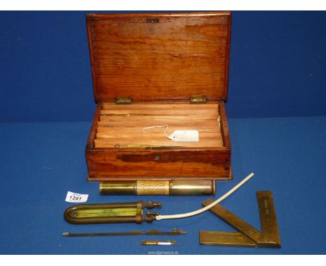 A wooden box and contents including brass mining engineering tools, instructions for Otis Kings Calculator, pocket draught ga