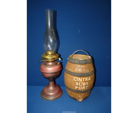 A Portuguese Cintra ruby port ceramic barrel, 10 1/2" tall and a metal Eltex oil Lamp with glass chimney, 21" tall.