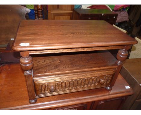 An Ercol Elm Coffee Table having a lower shelf with a frieze drawer below and a triangular drop-leaf to one side/the back, 29