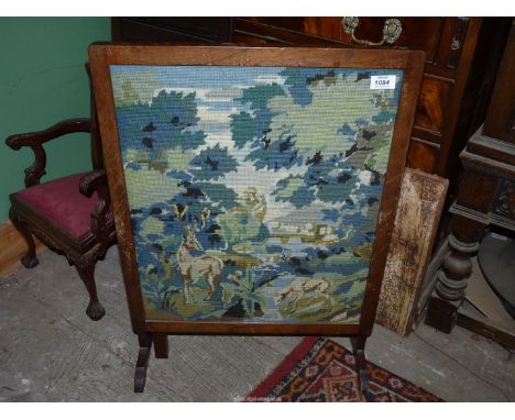 A Fire screen converting to a Table with a glass top and tapestry under depicting a woodland scene with deer, 28 1/2" x 20" w