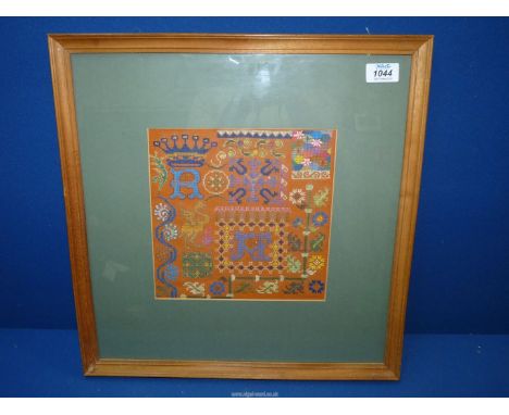 A framed and glazed cross-stitch Sampler, multi-coloured, 17 1/4" x 17 1/4".