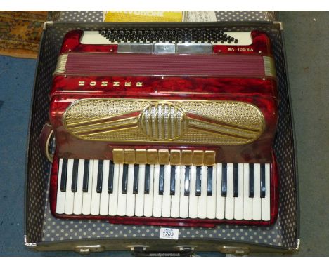A cased red Hohner Verdi VS Accordion.
