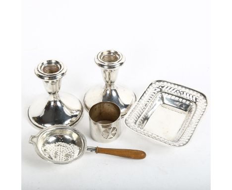 A pair of squat weighted silver candlesticks, a tea strainer, Maltese silver napkin ring etc 