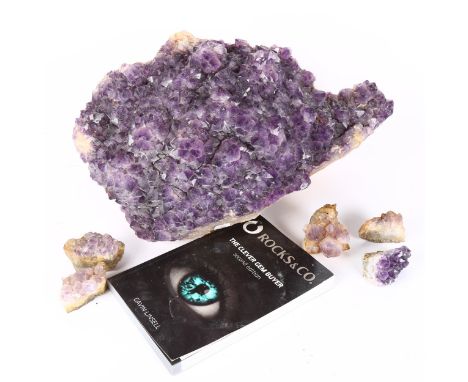 A large amethyst geode rock sample, 5 smaller amethysts samples, and a gem book, largest sample width 42cm