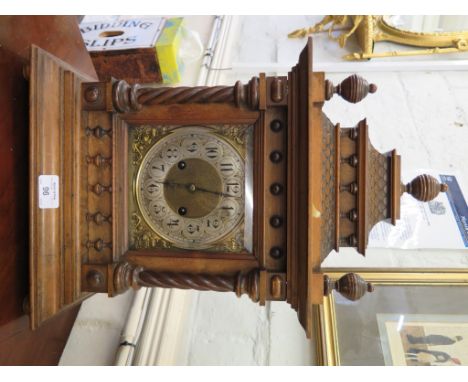 An Edwardian walnut mantel clock, the tile effect caddy top over a brass dial flanked by columns, the twin train H.A.C. movem