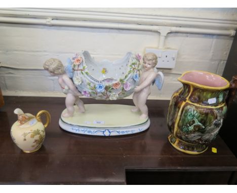 A Royal Worcester jug, with floral decoration 14cm high, a large Sitzendorf sweetmeat dish carried by two cherubs and a Germa