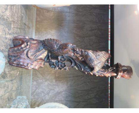 An Oriental carved wood lamp base depicting two birds and blossom