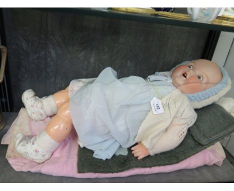 An Armand Marseille bisque doll, no 518/9K with blue sleepy eyes, open mouth and two teeth on a composite body, 60cm long
