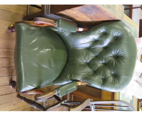 A Victorian leather upholstered armchair, the arched button back over padded scroll arms on turned legs