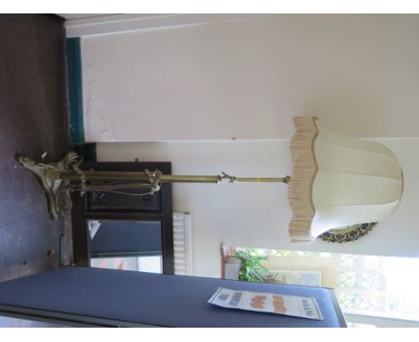 An Edwardian brass adjustable standard lamp, on a scrolling tripod base
