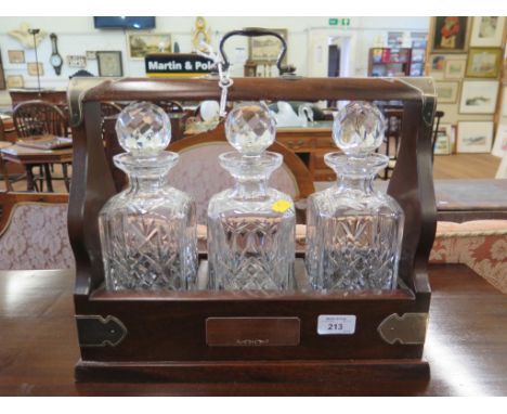 A three decanter mahogany tantalus, with key and silver plated mounts, 37cm wide