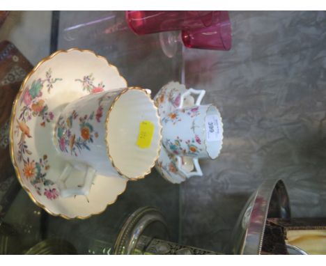 A pair of 18th century two handled tea/chocolate cups and saucers, with enamelled Kakiemon design of birds in floral branches