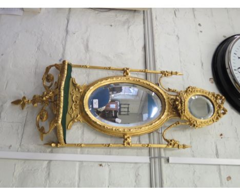 A French giltwood wall mirror, the oval bevelled plate with floral swags over a shelf on floral supports, 100cm high