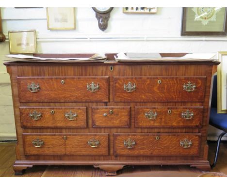 A George III oak and mahogany crossbanded mule chest, the hinged top over two dummy drawers, above an arrangement of five dra