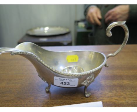 A silver plated gravy boat together with a plated ladle