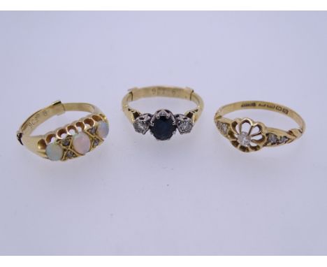 THREE 18CT GOLD DRESS RINGS to include a diamond set example with openwork flower head and leaf design shoulders, size mid O-