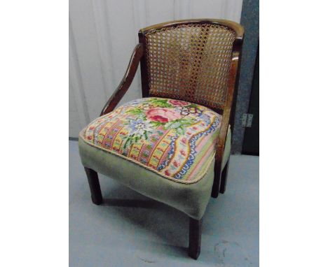 An early 20th century tub chair with tapestry seat and caned back