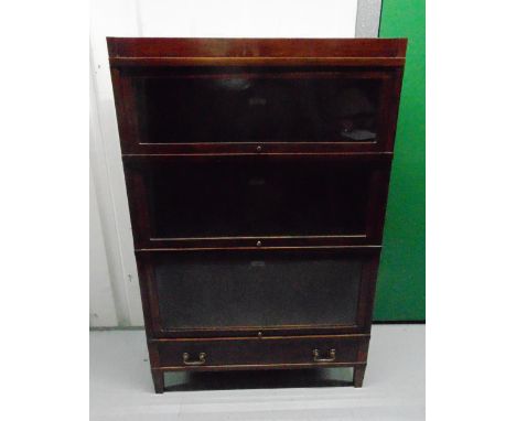 An original Globe Wernicke rectangular mahogany three section glazed bookcase with base single drawer and brass handles, 135.