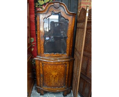 A Dutch bowfront floral marquetry walnut standing corner cabinet in two parts, the upper with arched top over a glazed-in doo