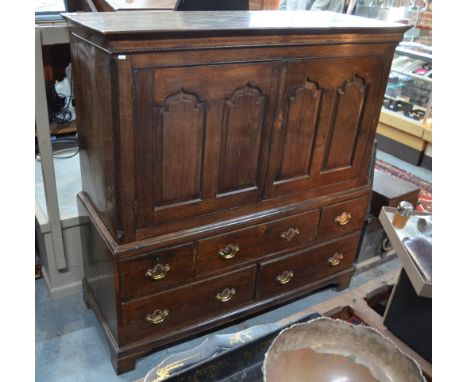 An 18th century and later converted oak cabinet on chest, the pair of twin Arabic arched panel cupboard doors over three shor