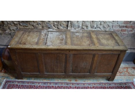 A late 17th/18th century oak jointed coffer, the hinged four panel top over a conforming front, on stile feet, 146 x 50 x 50 