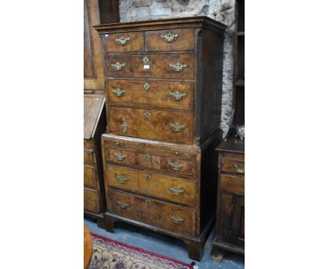 An 18th century feather-banded walnut chest on chest, two short over three long graduated drawers flanked by canted corners, 