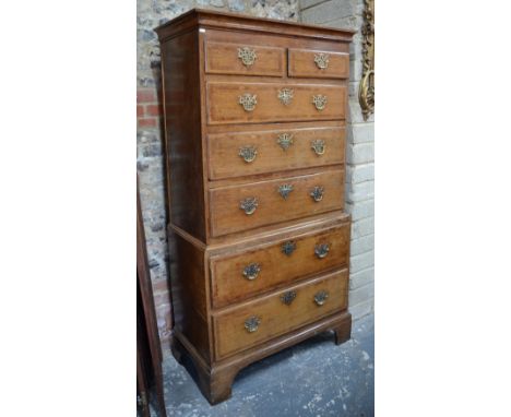 An 18th century cross-banded oak chest on chest, with thwo short over five long graduated drawers, raised on shaped bracket f