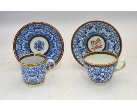 An 18th century Worcester blue and white teacup and saucer, the cup with twisted handle, red and gilt flower to centre of sau